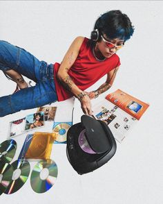 a man with headphones and sunglasses on top of a table filled with cd's