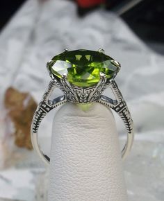 Natural Green Peridot Ring  100 Year Design#37 Made To Order This is a brand new Edwardian circa 1910 reproduction filigree ring in sterling silver. The round full cut high-quality approximately 6ct Natural green peridot is 12mm (just shy of 1/2th of an inch) in diameter (The 2ct Natural Peridot option is also available, the 2ct version of this ring has a 9mm gemstone, see least picture in set). The peridot is a genuine natural earth-mined gemstone and thus has slight minor inclusions inherent t Peridot Aesthetic, Elk Ivory, Stock Design, Peridot Jewelry, Order Design, Peridot Green, Buffet Food, Luxury Rings, Sterling Silver Filigree