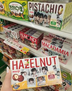 a person holding up a box of hazelnuts in a store aisle with other items on the shelves