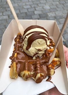 an ice cream sundae with chocolate drizzled on top in a box