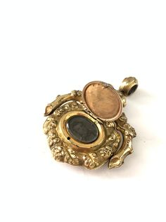 Antique Victorian Gold Filled Agate Spinner Locket Fob, Gold Filled Agate Locket, Victorian Locket, Gift for Him Amazing antique locket, one side has a beautiful agate cabochon and the other side, has an engraved center that opens to reveal a little hidden compartment with a photo. It might be a little hard to see the photo inside in the pictures, but if you look closely, there is a photo of a gentlemen inside. I'm not sure if you can remove this photo and place your own inside as I have not tri