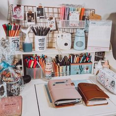 an organized desk with pens, notebooks and other office supplies on top of it