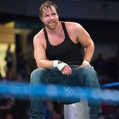 a man sitting on top of a metal pole next to a blue net in front of a crowd