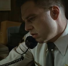 a man in uniform talking on a telephone