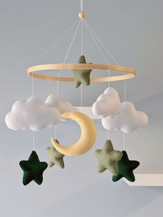 a mobile with stars, moon and clouds hanging from it