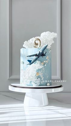 a blue and white cake with an airplane on top