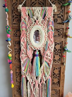 a decorative wall hanging with tassels and other items on it's side