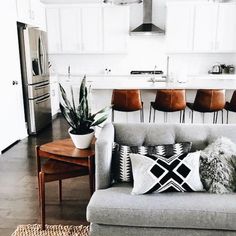 a living room filled with furniture next to a kitchen