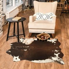 a living room with a cow hide rug on the floor and a chair next to it