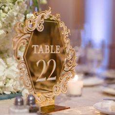 the table number is displayed in front of white flowers