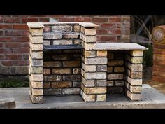 an outdoor oven made out of bricks in front of a brick wall