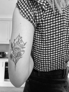 a woman with a flower tattoo on her left arm and right arm behind her back