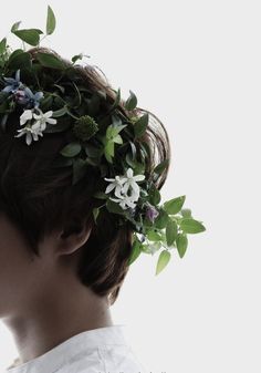 a young man with a flower crown on his head