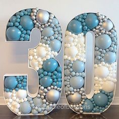 the number thirty is decorated with blue and white balls