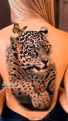 a woman's back tattoo with a leopard and butterflies on it