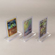 three clear acrylic cards are displayed on a white surface with no one in the photo