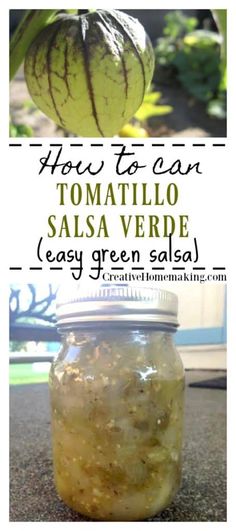 a jar filled with green salsa sitting on top of a counter next to a plant