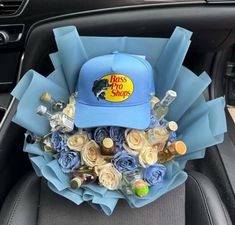 a blue hat sitting on top of a bouquet of flowers in the back seat of a car