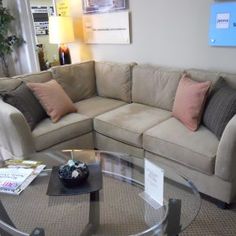 a living room filled with furniture and a round glass table in front of the couch