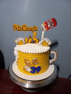 a birthday cake with the simpsons character on top and beer can in the middle, sitting on a table