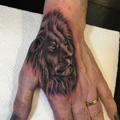 a man's hand with a lion tattoo on it