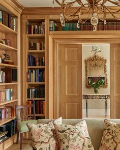 a living room filled with furniture and bookshelves covered in lots of bookcases