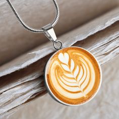 a cappuccino necklace with a leaf on it