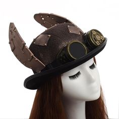 Discover the magnificent Steampunk Hat and Goggles. An original steampunk hat with two wings on the sides. A wonderful journey into the original world of steampunk. With leather straps to give an industrial effect and a famous pair of goggles to give the final touch to the hat. Steampunk Costume Accessories With Brimmed Shape, Steampunk Brimmed Costume Accessories For Party, Steampunk Brimmed Costume Accessories For Costume Party, Steampunk Costume Top Hat, Steampunk High Crown Costume Accessories For Cosplay, Steampunk Halloween Costume Accessories, Steampunk Adjustable Hat For Costume Party, Steampunk Adjustable Costume Hats And Headpieces, Adjustable Steampunk Top Hat For Themed Events