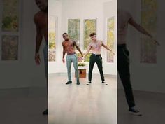 two men are dancing in the middle of a room