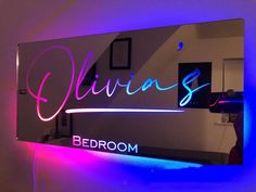 a mirror with the word bedroom written on it and neon lights in front of it