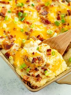 a casserole dish with potatoes, bacon and green onions