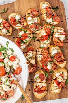 a wooden cutting board topped with slices of bread covered in tomatoes and mozzarella