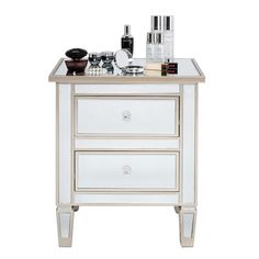 an image of a white and gold nightstand with cosmetics on it's side table