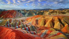 an image of colorful hills and valleys in the mountains with text that reads visite le gans, kaleidoscope ethnue et culture du nord - ouest de la chinne