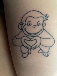 a monkey with a heart tattoo on its leg is smiling and holding onto the arm