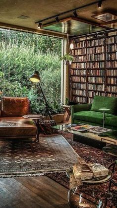 a living room filled with lots of green furniture and bookshelves full of books