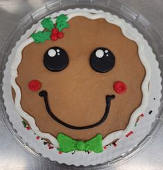 there is a cake decorated to look like a smiling face with holly wreaths on it