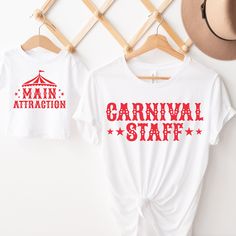 two t - shirts with the words carnival staff and main attraction on them hanging up