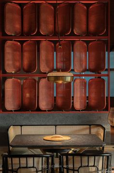 a table and some chairs in front of a wall with red trays on it