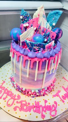 a birthday cake with pink, blue and purple icing