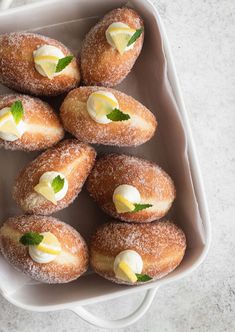 powdered doughnuts with butter and mint in a white dish on a marble surface