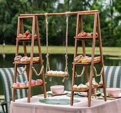 an outdoor table set up with desserts and teacups for two people to enjoy