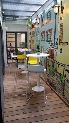 an indoor dining area with tables and chairs, painted on the wall in yellow and blue