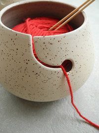 a bowl with yarn in it and two knitting needles sticking out of the top one