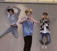 three boys jumping in the air with their hands up