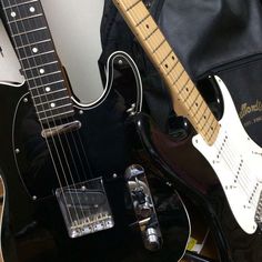 two electric guitars sitting next to each other