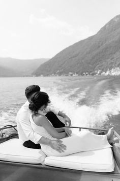 a man and woman sitting on the back of a boat