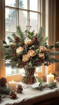 a vase filled with roses and pine cones on top of a table next to candles