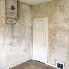 an empty room with a door, heater and radiator on the wall