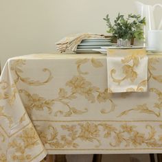 a table topped with plates and napkins next to a vase filled with flowers on top of a wooden table